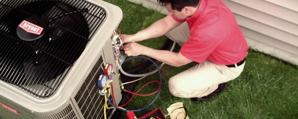 HVAC technician servicing an outdoor air conditioner unit in San Diego, CA