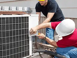 HVAC technicians repairing an outdoor AC unit on a rooftop in San Diego, CA