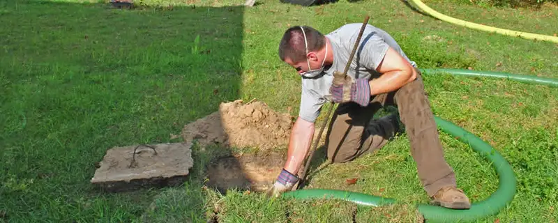 Septic pumping technician servicing a residential septic tank in San Diego, CA